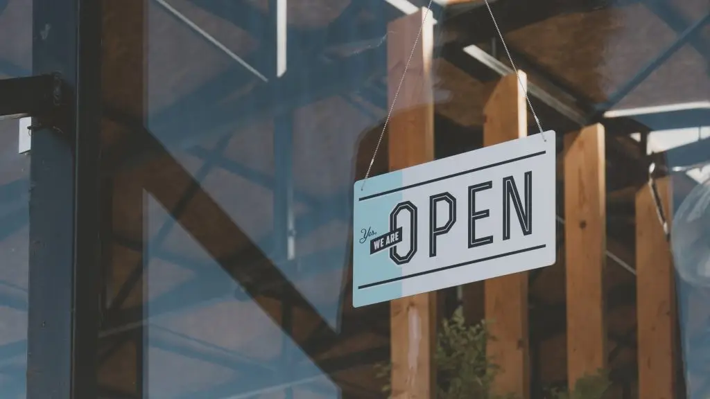 Yes, We Are Open sign hanging in a glass storefront window.